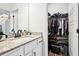 Bathroom vanity with granite countertop, black faucet, and open closet space for easy storage at 4189 Brookmont Way, Auburn, GA 30011