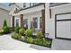 Inviting front porch with dark wood columns, colorful flowers and a seating area at 4189 Brookmont Way, Auburn, GA 30011