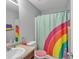 Colorful bathroom featuring a rainbow shower curtain, vanity, and toilet at 4240 N Braves Cir, Douglasville, GA 30135