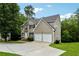 Two-story home with a two-car garage, stone accents, lush landscaping, and a curved driveway at 4240 N Braves Cir, Douglasville, GA 30135