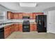 Kitchen featuring wood cabinets, black appliances, and ample counter space at 4240 N Braves Cir, Douglasville, GA 30135