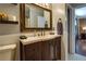 Stylish bathroom with a wood vanity, decorative mirror, and doorway leading to bedroom at 224 Amy Blvd, Temple, GA 30179