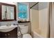 Well-lit bathroom boasting a vanity with mirror, tub and shower, and a window with natural light at 224 Amy Blvd, Temple, GA 30179