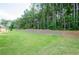 Manicured green lawn leads to a tree-lined perimeter in this spacious backyard at 3405 Linstead Ct, Loganville, GA 30052