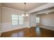 Dining room features hardwood floors, chandelier, wainscotting, and large windows at 3405 Linstead Ct, Loganville, GA 30052
