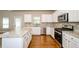 Spacious kitchen featuring granite counters, stainless steel appliances, and hardwood floors at 3405 Linstead Ct, Loganville, GA 30052