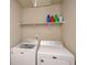 Functional laundry room with a washer, dryer, and overhead shelving for storage at 3405 Linstead Ct, Loganville, GA 30052