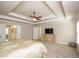 Bedroom featuring a tray ceiling, neutral colors, and an adjoining bathroom at 3405 Linstead Ct, Loganville, GA 30052