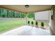 Covered patio with gray tile and square planters overlooks a large, green yard with mature trees at 3405 Linstead Ct, Loganville, GA 30052