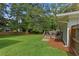 Spacious backyard with a deck, mature trees and lush lawn, perfect for outdoor activities at 470 Pretty View Se Ln, Smyrna, GA 30082