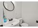 Bright half-bathroom featuring an oval mirror above the white vanity with a framed mirror at 470 Pretty View Se Ln, Smyrna, GA 30082
