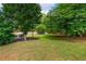 Lush green backyard surrounded by mature trees and landscaping, offering privacy and serene outdoor space at 2000 Settindown Dr, Roswell, GA 30075