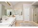 Neutral primary bathroom with double vanity, white cabinets, and large mirrors at 2000 Settindown Dr, Roswell, GA 30075