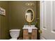 Olive powder room featuring a stylish vanity with marble countertop and a decorative oval mirror at 2000 Settindown Dr, Roswell, GA 30075