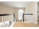 Upstairs hallway with window, white railings and tan carpet at 2000 Settindown Dr, Roswell, GA 30075