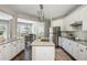 Gourmet kitchen with white cabinets, granite countertops, stainless steel appliances, and dining area access at 2000 Settindown Dr, Roswell, GA 30075