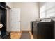 Laundry room featuring tile floors, a utility sink, modern black appliances, and natural light at 2000 Settindown Dr, Roswell, GA 30075