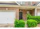 Close up of the brick townhome with a garage, front door and manicured landscaping at 2555 Flat Shoals Rd # 2006, Atlanta, GA 30349