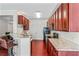 An open kitchen features stone countertops, cherry cabinets, and modern appliances at 2555 Flat Shoals Rd # 2006, Atlanta, GA 30349