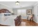 Comfortable bedroom with hardwood floors, decorative bed frame, natural light, and accent chair at 420 Heritage Park Nw Trce # 22, Kennesaw, GA 30144