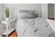 Bright bedroom features a double bed, hardwood floors, and a side table with a lamp and plant at 420 Heritage Park Nw Trce # 22, Kennesaw, GA 30144