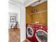 Efficient laundry area with modern red washer and dryer, convenient shelving, and adjacent seating at 420 Heritage Park Nw Trce # 22, Kennesaw, GA 30144