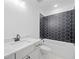 Modern bathroom with black hexagonal tiles surrounding the tub and shower, plus a white vanity at 461 Maypop Ln, Woodstock, GA 30188