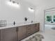 Modern bathroom with double sinks, quartz countertop, wood cabinets and a glimpse of a green view at 461 Maypop Ln, Woodstock, GA 30188