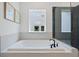 Elegant bathroom featuring a soaking tub, sleek fixtures, and a private backyard view at 461 Maypop Ln, Woodstock, GA 30188