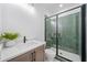 Modern bathroom features a glass-enclosed shower with vibrant green tiles and stylish fixtures at 461 Maypop Ln, Woodstock, GA 30188