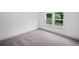 Bright bedroom featuring neutral carpet, white walls, baseboards, and double windows with peaceful outdoor views at 461 Maypop Ln, Woodstock, GA 30188