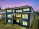 Back exterior of blue two-story home with a wooden balcony, abundant windows, and green lawn at 461 Maypop Ln, Woodstock, GA 30188
