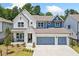 Charming two-story home featuring a three-car garage, white brick, and manicured landscaping at 461 Maypop Ln, Woodstock, GA 30188