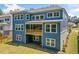 Back exterior of a blue two-story home featuring a wooden balcony and ample windows at 461 Maypop Ln, Woodstock, GA 30188