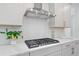 Kitchen features stainless steel hood over range, white countertops and cabinets at 461 Maypop Ln, Woodstock, GA 30188