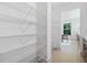 Walk-in pantry features wire shelving, white walls and floors with view to kitchen at 461 Maypop Ln, Woodstock, GA 30188