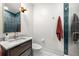 Modern powder bathroom with marble countertops, a shower with blue tiling, and a framed mirror at 845 Spring Nw St # Ph4, Atlanta, GA 30308