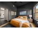 Contemporary bedroom featuring dark walls, fan, neutral rug, and large window with views at 845 Spring Nw St # Ph4, Atlanta, GA 30308