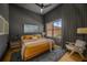 Modern bedroom with dark walls, fan, and large window with city views at 845 Spring Nw St # Ph4, Atlanta, GA 30308
