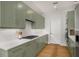 Modern kitchen featuring sage cabinets, quartz countertops, stainless appliances, and hardwood floors at 845 Spring Nw St # Ph4, Atlanta, GA 30308