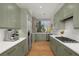 Stylish kitchen featuring sage cabinets, stainless appliances, quartz countertops, and hardwood floors at 845 Spring Nw St # Ph4, Atlanta, GA 30308