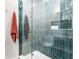 Shower with blue tiling, glass doors, and a built-in nook for toiletries, complete with gold fixtures at 845 Spring Nw St # Ph4, Atlanta, GA 30308