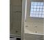 Bathroom featuring a tub and shower with glass block window at 955 Loch Forest Way, Riverdale, GA 30296