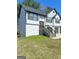 Charming home featuring a two-car garage, a well-maintained lawn, and stairs leading to the front door at 955 Loch Forest Way, Riverdale, GA 30296