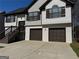 Charming home featuring a two-car garage, a well-maintained lawn, and stairs leading to the front door at 955 Loch Forest Way, Riverdale, GA 30296