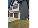 Side view of a two-story house with a two-car garage and air conditioning unit at 955 Loch Forest Way, Riverdale, GA 30296