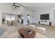 Open-concept living room features light wood floors, modern furniture, and flows into the kitchen and dining area at 337 Theodore Cox Cir, Canton, GA 30114