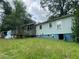 The backyard view reveals a wooden deck and light blue siding, complemented by an overgrown lawn at 2096 Boar Tusk Ne Rd, Conyers, GA 30012