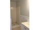 White-tiled shower stall and white vanity, with gray walls, chair railing and neutral tile flooring at 1053 Metropolitan Parkway Southwest Sw Pkwy, Atlanta, GA 30310