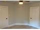 Bedroom featuring new gray laminate flooring, freshly painted neutral walls, and two doors at 1053 Metropolitan Parkway Southwest Sw Pkwy, Atlanta, GA 30310